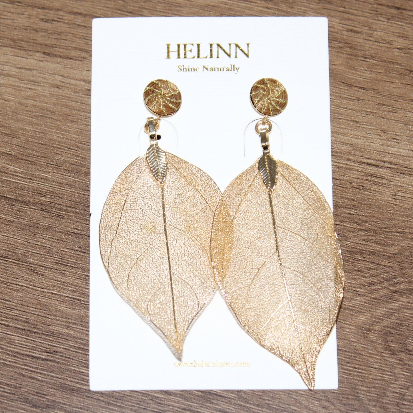 Woman wearing Aura Leaf Statement Earrings handcrafted with Brazilian Golden Grass and delicate gold botanical leaf pendant.