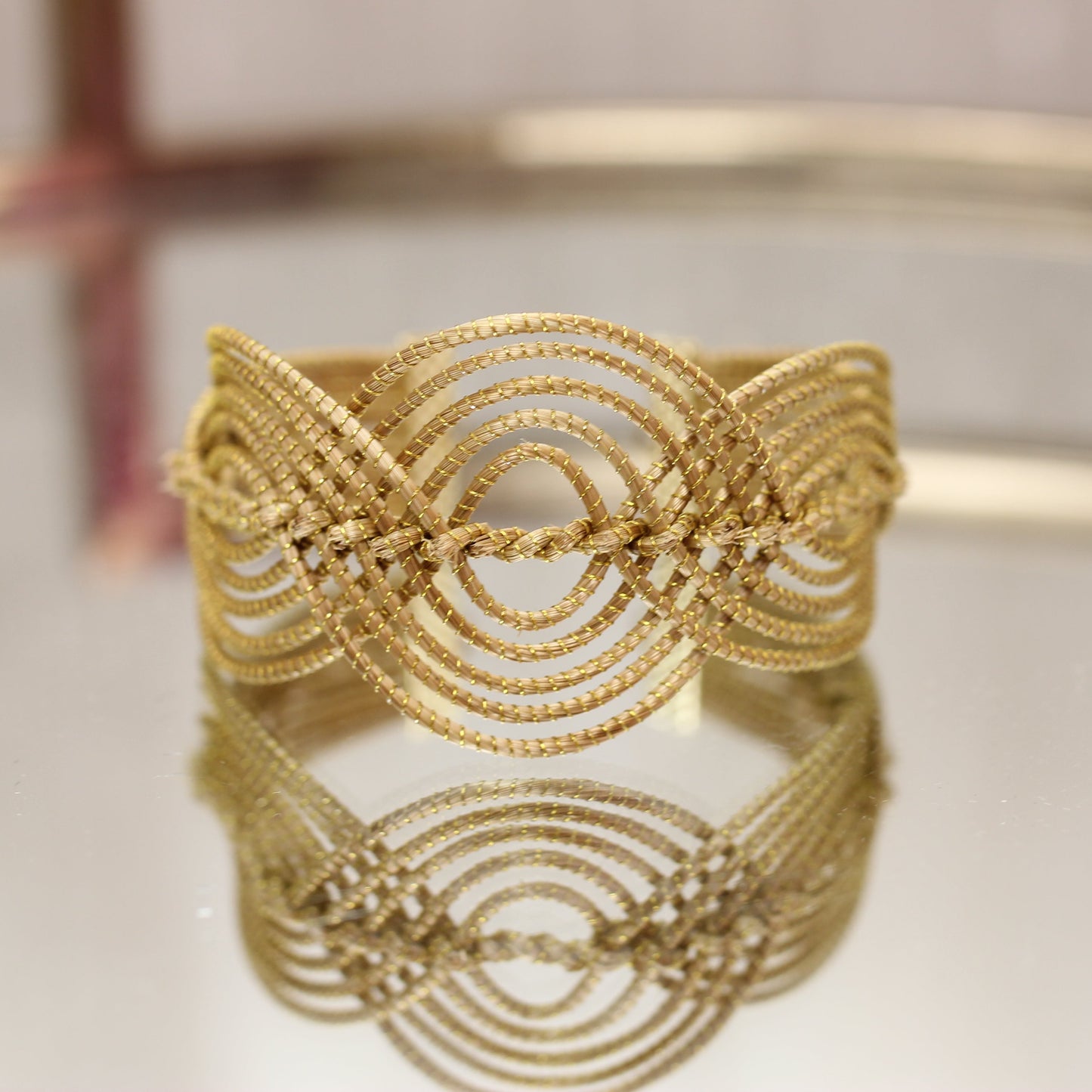 Woman wearing Helinn Mistério da Terra golden grass cuff bracelet styled with natural linen clothing in warm sunlight