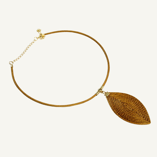 A gold-toned snake chain necklace featuring a large, textured leaf-shaped pendant, displayed on a clean white background.