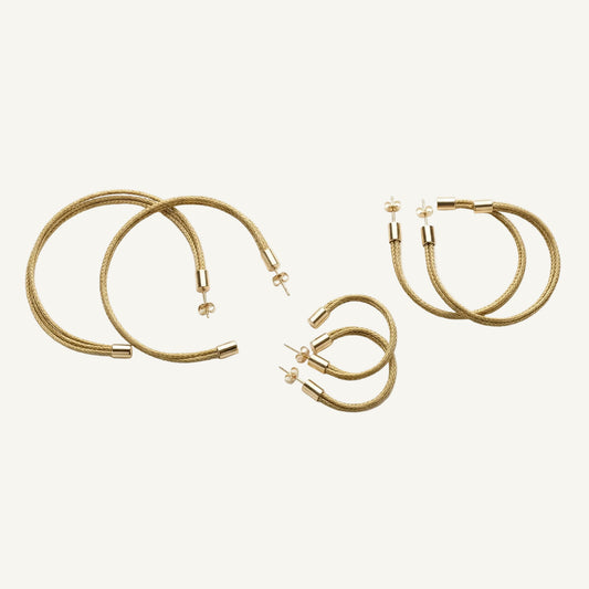 Set of gold necklaces and hoop earrings on a white background