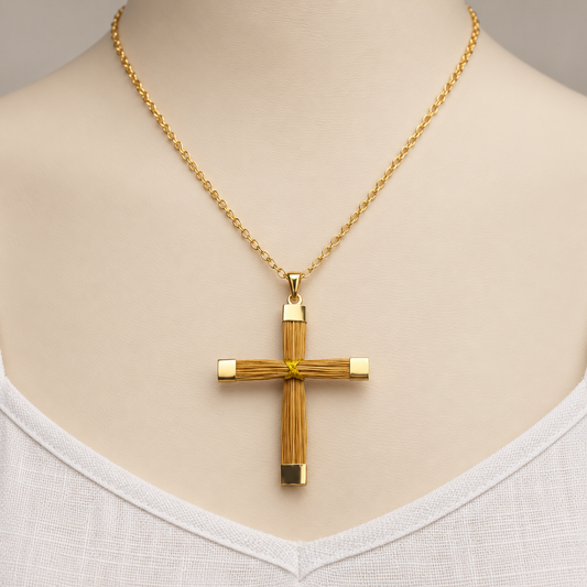A gold chain necklace with a cross pendant featuring a textured, wood-like vertical design and small gold end caps, displayed on a beige mannequin bust wearing a white top.