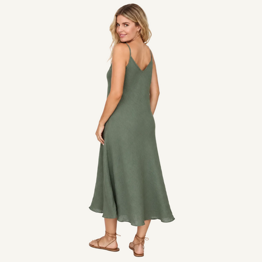A woman modeling a sleeveless olive green midi slip dress with a V-neckline, shown from a three-quarter back angle against a plain white studio background.