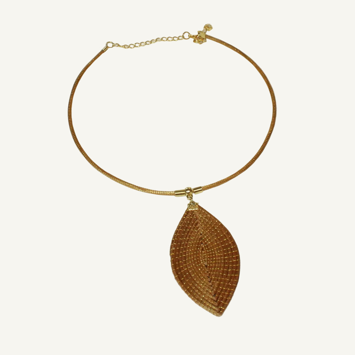 Vida Folha Dourada Necklace handcrafted from Golden Grass featuring a woven leaf-shaped pendant on a gold-tone chain.