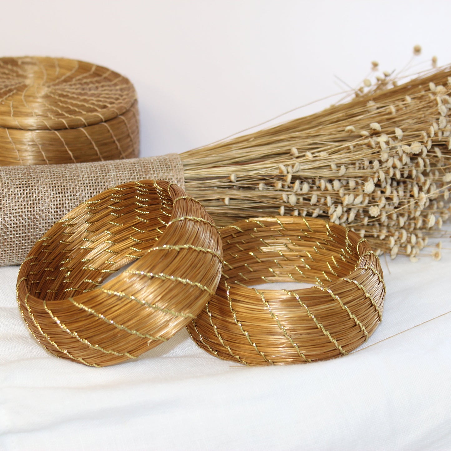 Set of woven baskets with a broom and burlap on a white background