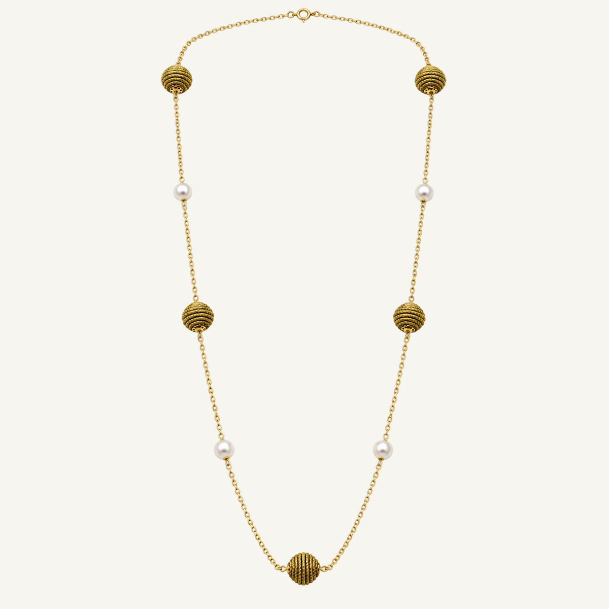 A gold chain necklace featuring five textured gold spherical beads and five small white pearls spaced along the chain, displayed on a clean white background.