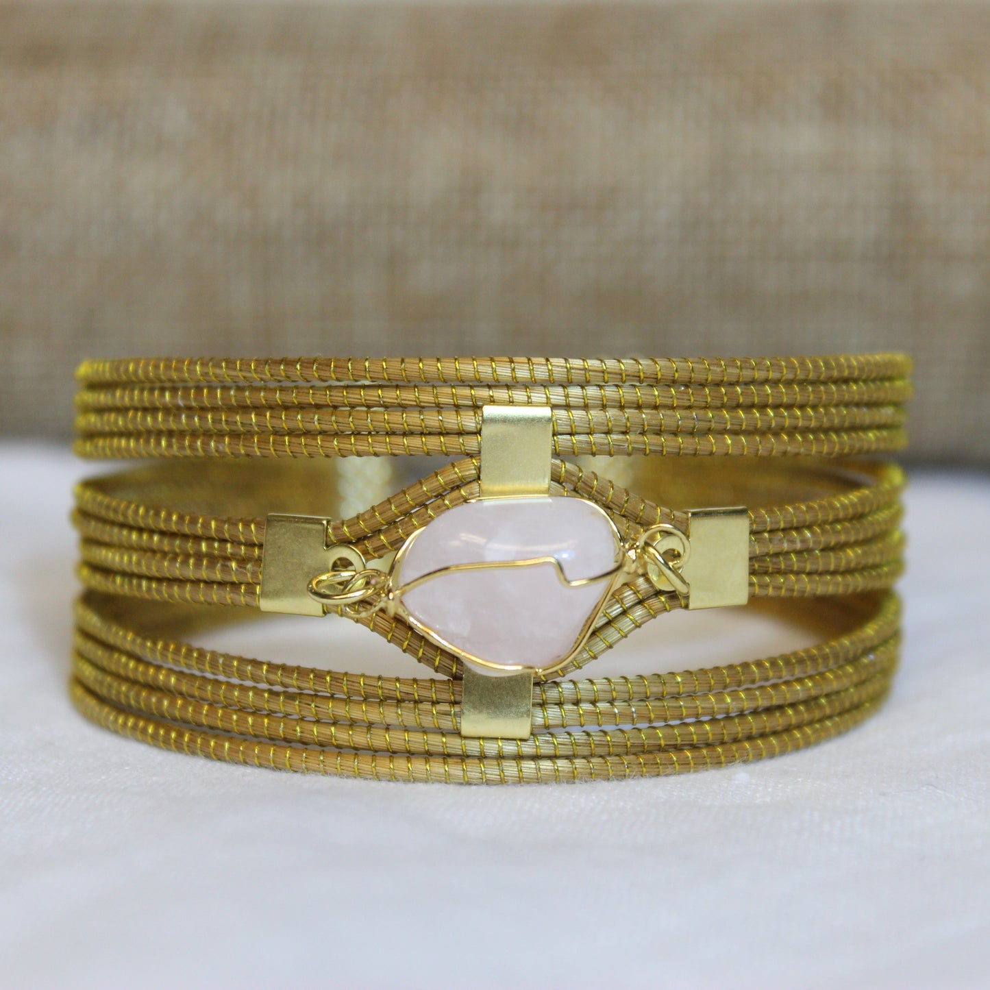 Vida Aurora Wrap Bracelet featuring green gold plated metal construction with natural stone centerpiece on white background.
