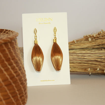 Handmade HELINN Folha Dourada Golden Grass leaf earrings displayed on natural artisan background.