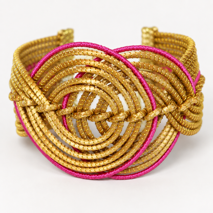 Close-up detail of the Vida Rosa Dourada Golden Grass Cuff Bracelet showing woven golden grass and pink spiral accents