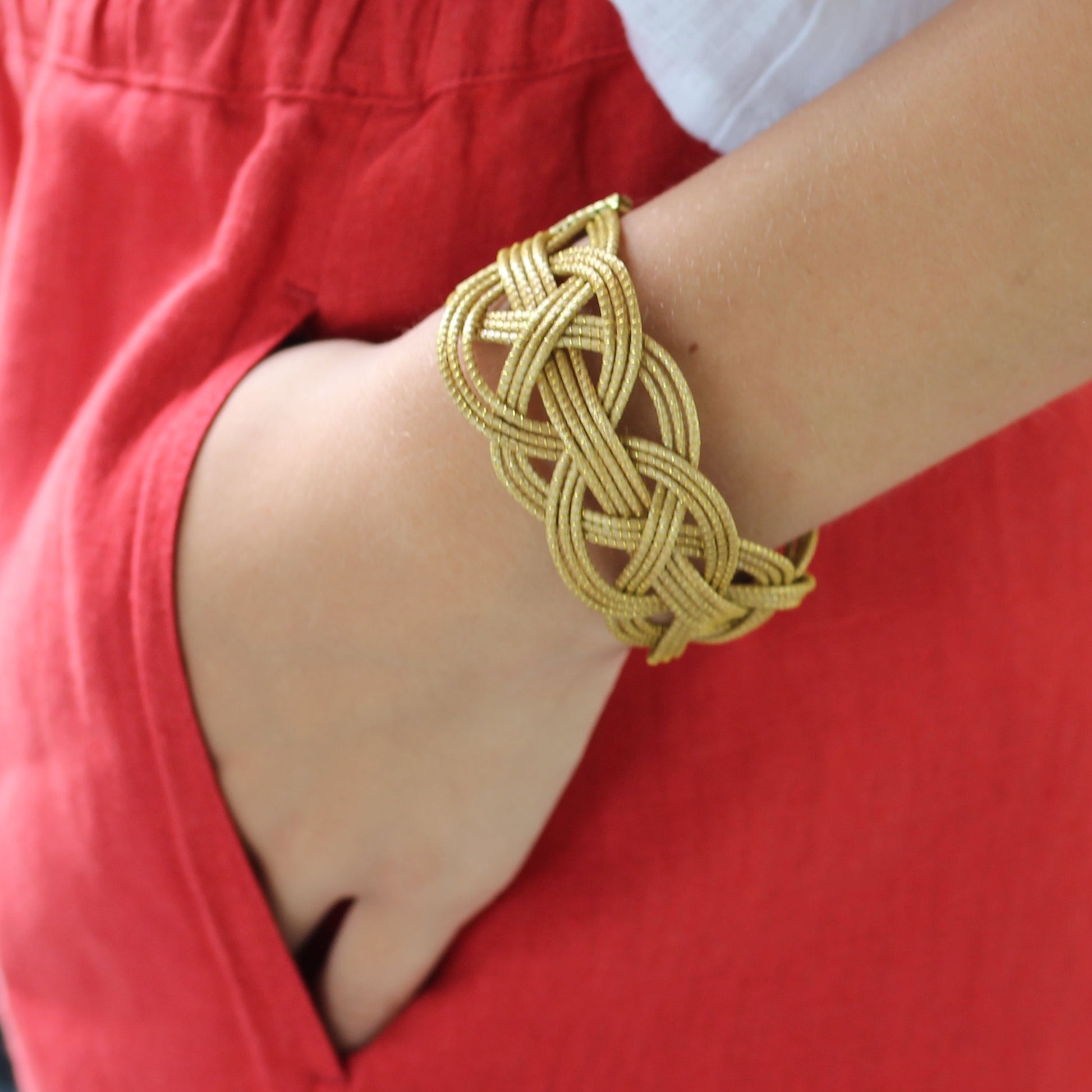 Gold bracelet on a wrist with a blurred background