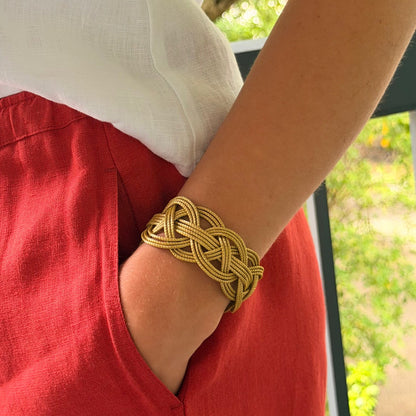 Horizonte Serena braided golden grass cuff bracelet styled with white linen top and red linen pants by HELINN