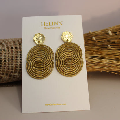 Gold spiral earrings on a Helinn branded card with a neutral background