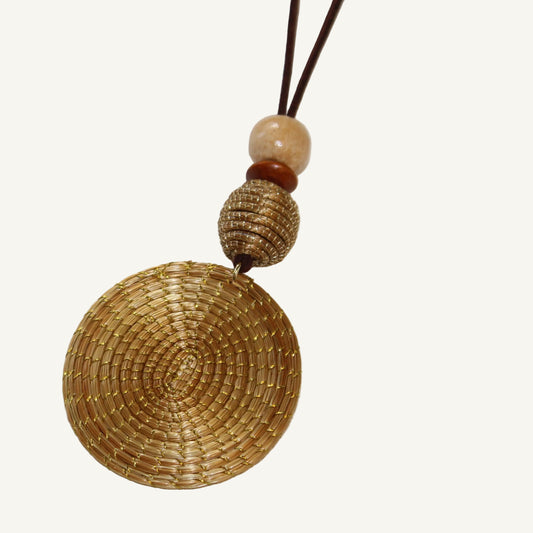 Two woven pendants on brown strings with beads against a white background