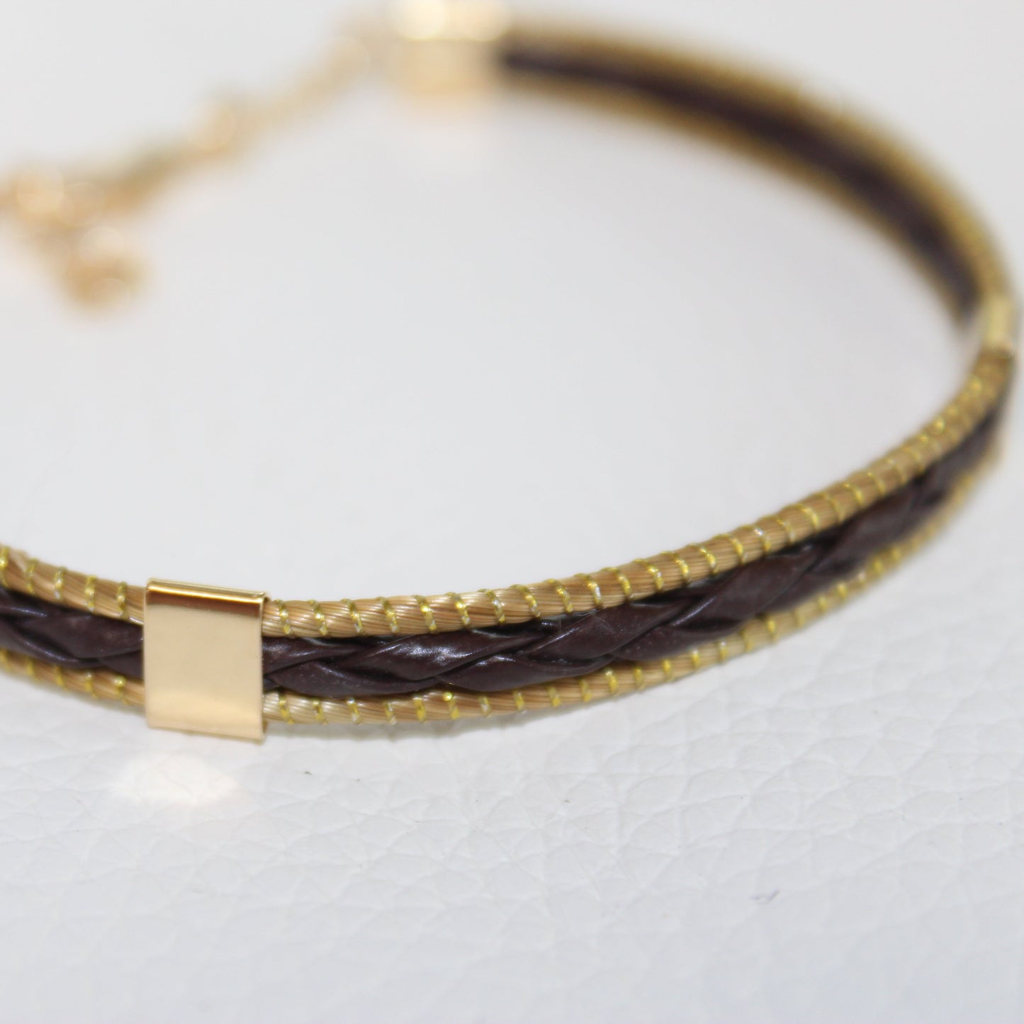Close-up of the braided leather and polished 18K gold-plated detailing on the HELINN Aura Slim Leather Bracelet.