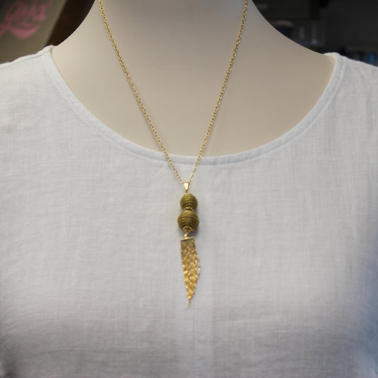 Handcrafted from Brazilian Golden Grass with premium 18K gold-plated details, the Aura Long Gold Drop Necklace features elegant woven spheres and a flowing tassel for timeless sophistication.