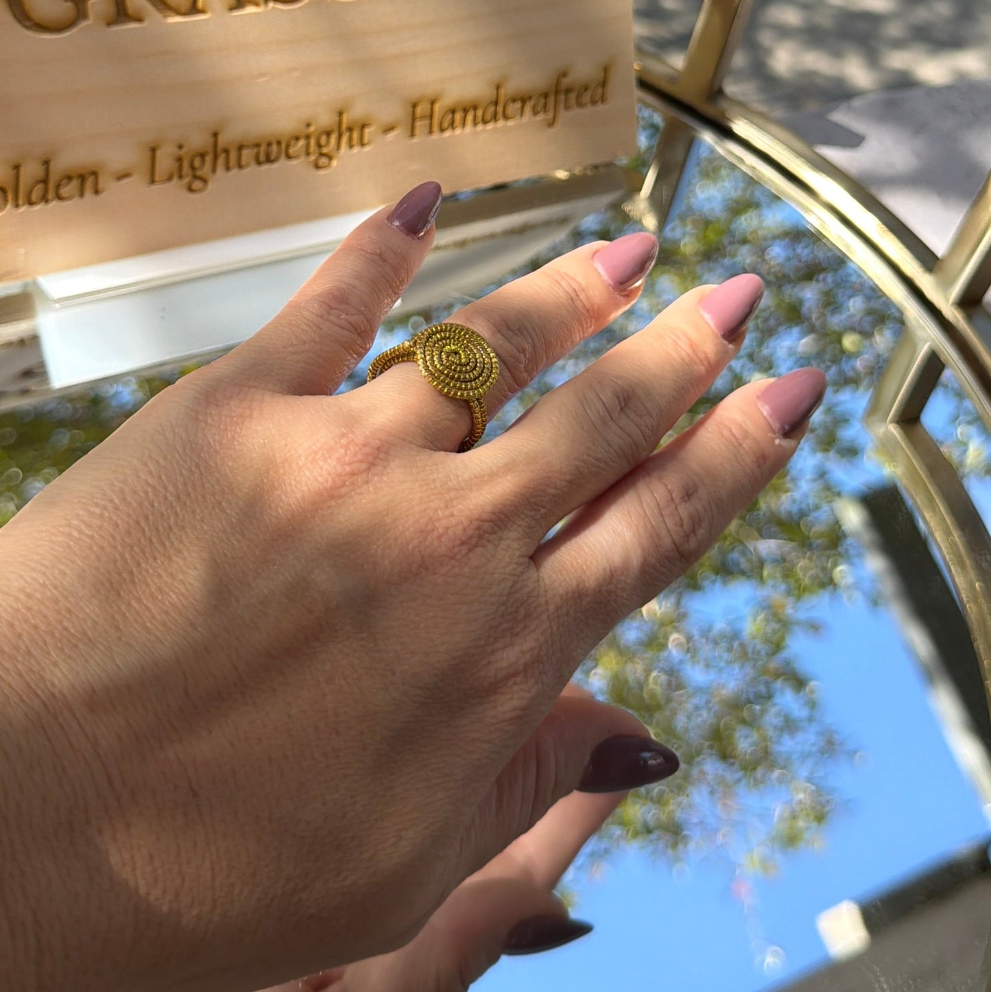 Hand holding a product with 'Golden Grass' branding outdoors.