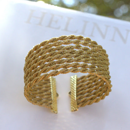 Handwoven golden grass cuff bracelet featuring a delicate braided lattice design inspired by natural light and horizon textures. Handmade artisan jewelry by HELINN.