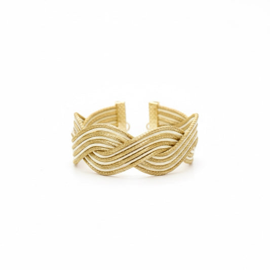 Handwoven golden grass cuff bracelet with beige detailing and natural sculptural curves. Lightweight artisan jewelry designed for effortless elegance.