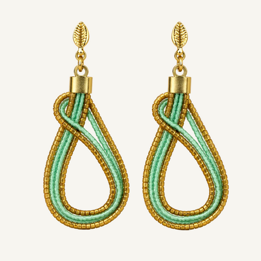 A pair of gold and mint green beaded teardrop dangle earrings on a clean white background.