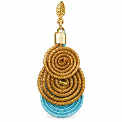 Close-up of Vida Maré Dourada handcrafted golden grass earring with aqua blue accent